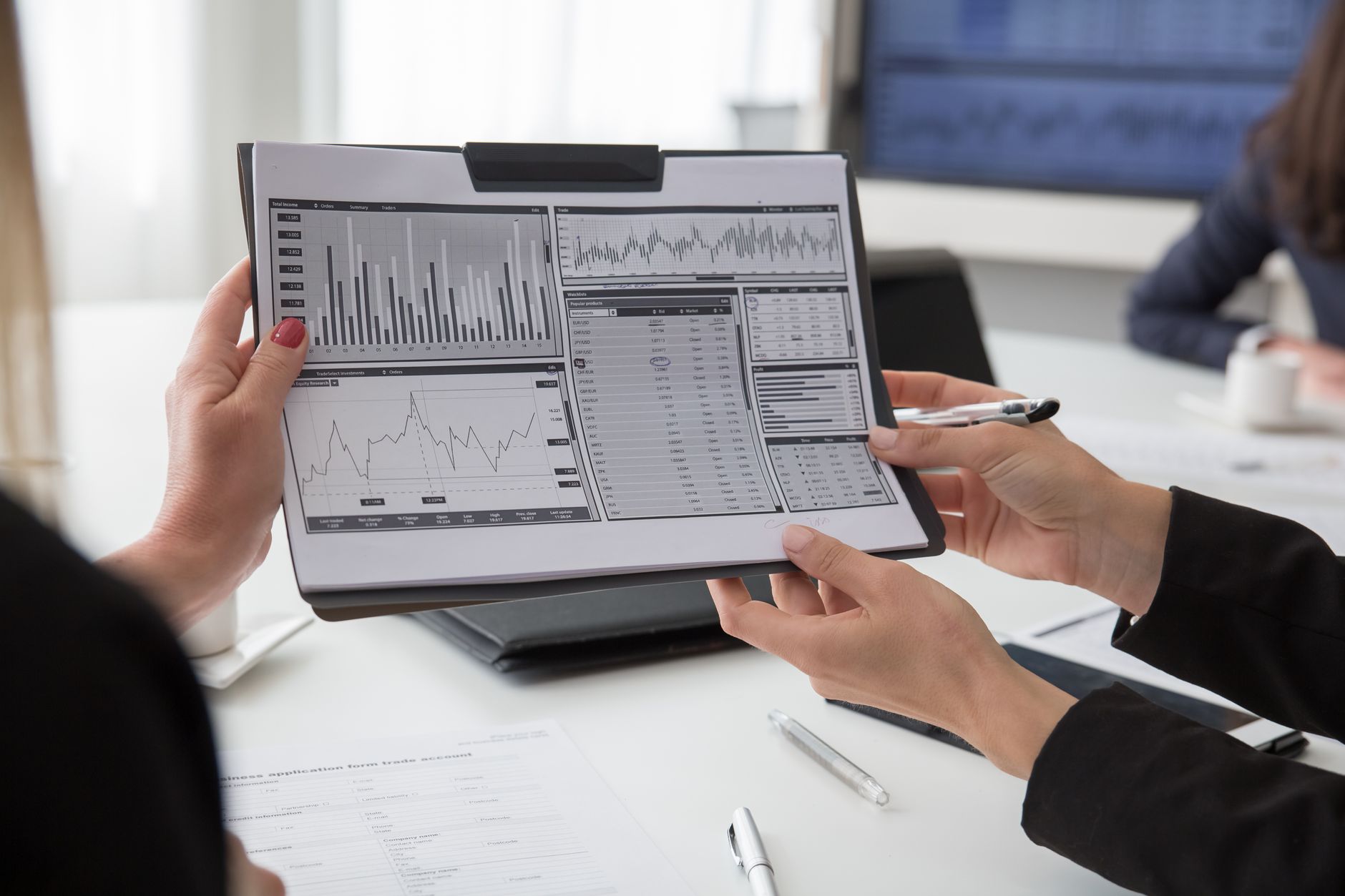 Professionals reviewing printed analytical reports during a meeting